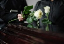 Two Pilots DIED Saving 72 Passengers Two individuals placing white roses on a coffin during a funeral