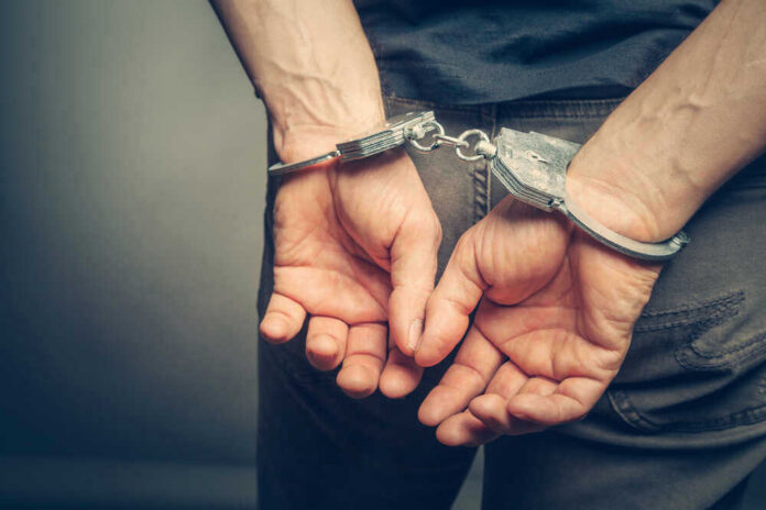 shutterstock_437224012.jpg Person with handcuffs behind their back.