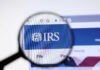 IRS AI Audit Machine Targets Retirees Magnifying glass focusing on IRS website logo.