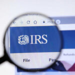 Magnifying glass focusing on IRS website logo.