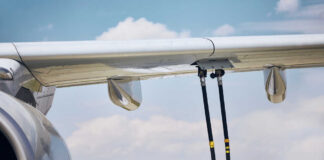 Close-up of an airplane wing being fueled by a ground support truck