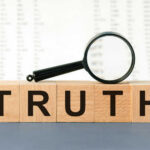 BRUTAL Truth — Half of America Struggling With Bills Wooden blocks spelling truth with magnifying glass
