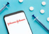 Smartphone displaying Johnson & Johnson logo with syringes and pills