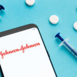 Smartphone displaying Johnson & Johnson logo with syringes and pills
