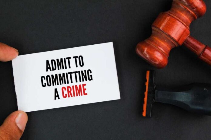 A hand holding a card that says 'ADMIT TO COMMITTING A CRIME' next to a gavel and a shaving razor