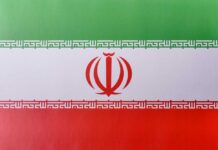 The flag of Iran featuring green, white, and red horizontal stripes with a central emblem