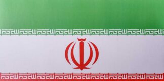 The flag of Iran featuring green, white, and red horizontal stripes with a central emblem