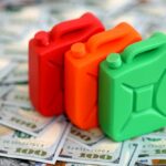 Three colorful plastic containers on a background of hundred dollar bills