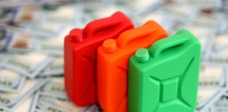 Three colorful plastic containers on a background of hundred dollar bills