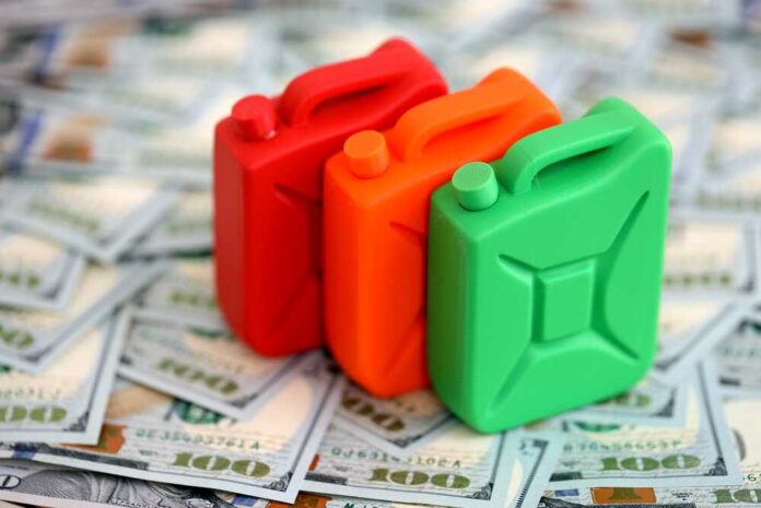 Three colorful plastic containers on a background of hundred dollar bills