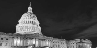 The U.S. Capitol building illuminated at night in black and white