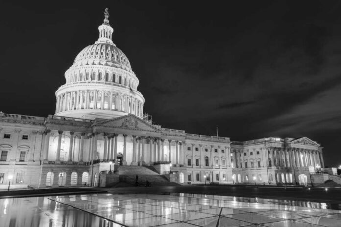 The U.S. Capitol building illuminated at night in black and white
