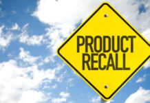Yellow product recall sign against cloudy sky