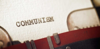 Close-up of a typewriter with the word 'COMMUNISM' typed on paper