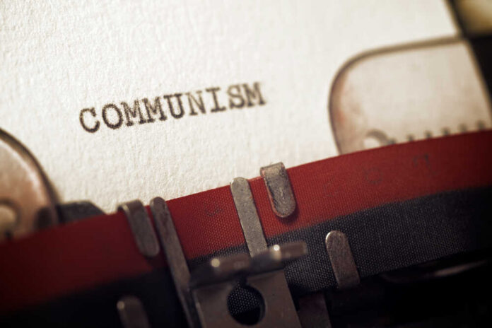 Close-up of a typewriter with the word 'COMMUNISM' typed on paper