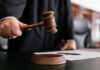 Judge holding gavel in courtroom.