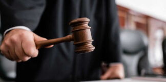Judge holding gavel in courtroom.