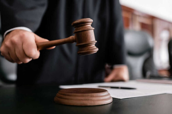 shutterstock_2121705137 Judge holding gavel in courtroom.