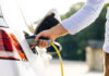 $9 Billion EV Gamble CRUSHES Automobile Company Person charging an electric vehicle.