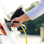 Person charging an electric vehicle.