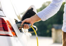 Person charging an electric vehicle.