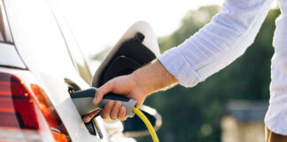 Person charging an electric vehicle.