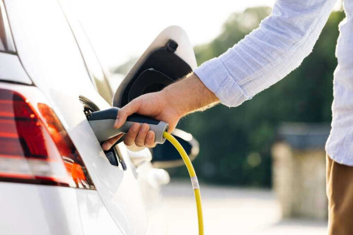 Person charging an electric vehicle.