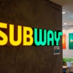 Illuminated Subway restaurant sign with green and yellow colors