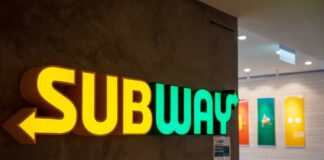 Illuminated Subway restaurant sign with green and yellow colors