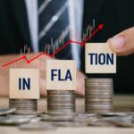 Electricity Bills TRIPLE Inflation — What’s Next? Blocks spelling 'INFLATION' placed on stacks of coins with a rising graph in the background