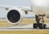 Close-up of an airplane engine and landing gear on a runway
