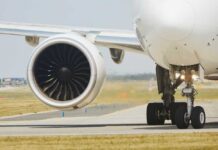 Close-up of an airplane engine and landing gear on a runway