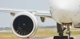 Close-up of an airplane engine and landing gear on a runway