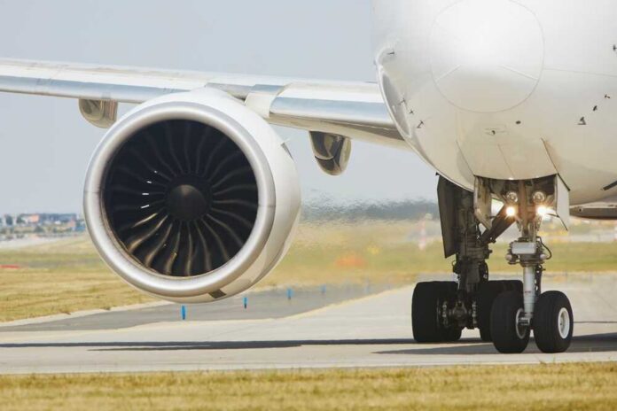 Close-up of an airplane engine and landing gear on a runway