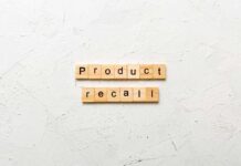 Wooden letter tiles spelling 'Product recall' on a textured surface
