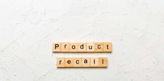 Wooden letter tiles spelling 'Product recall' on a textured surface