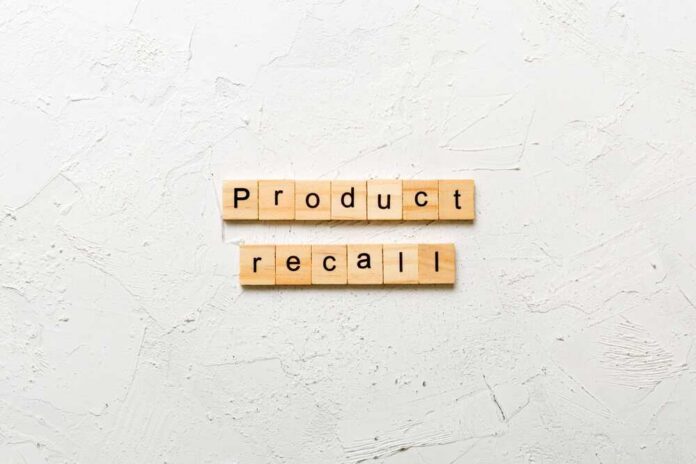 Wooden letter tiles spelling 'Product recall' on a textured surface