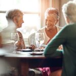 Group of senior women enjoying a meal and conversation at a table