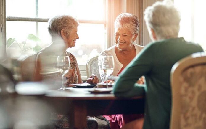 Group of senior women enjoying a meal and conversation at a table