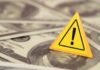 Massive $1.8B Fund: Corruption or Justice? A yellow warning sign on a background of dollar bills