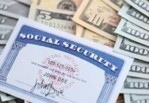 A social security card placed on top of various denominations of U.S. currency