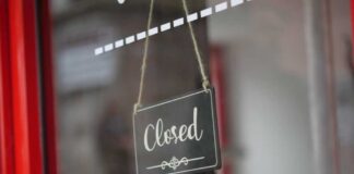 A closed sign hanging on a shop window