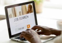 Jobs Boom? The Hidden Catch Person searching for jobs on a laptop.