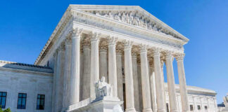Supreme Court building with columns, fountain, and statue.