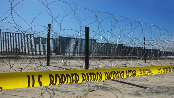 Border patrol tape and barbed wire fence.