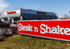 Exterior view of a Steak 'n Shake restaurant with a striped awning