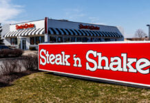Exterior view of a Steak 'n Shake restaurant with a striped awning