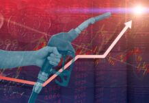 Oil Panic Looms — $160 In Weeks? Hand holding a fuel nozzle with rising graph lines in the background