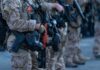 Law enforcement officers in tactical gear holding weapons