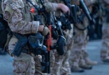Deadly Hit Takes Down Gang Kingpin Law enforcement officers in tactical gear holding weapons